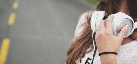 Mulher com fone de ouvido branco no pescoço.
